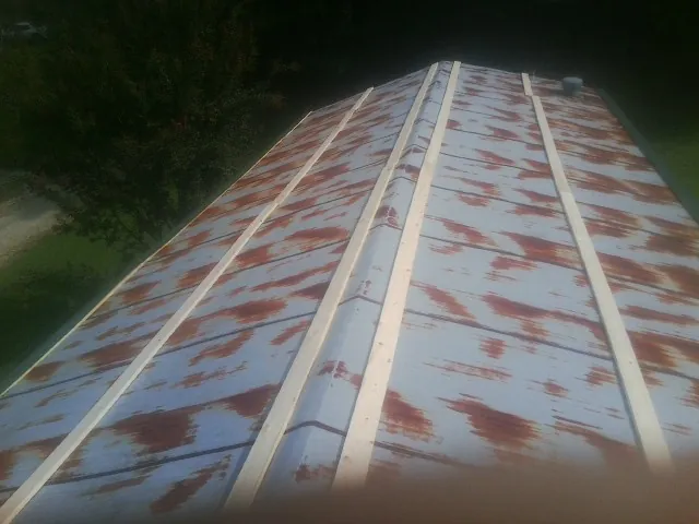 Rusted metal roof panels with new wood purlins before replacement — Storm Damage Roof Repair in Hull by Roofing Brothers
