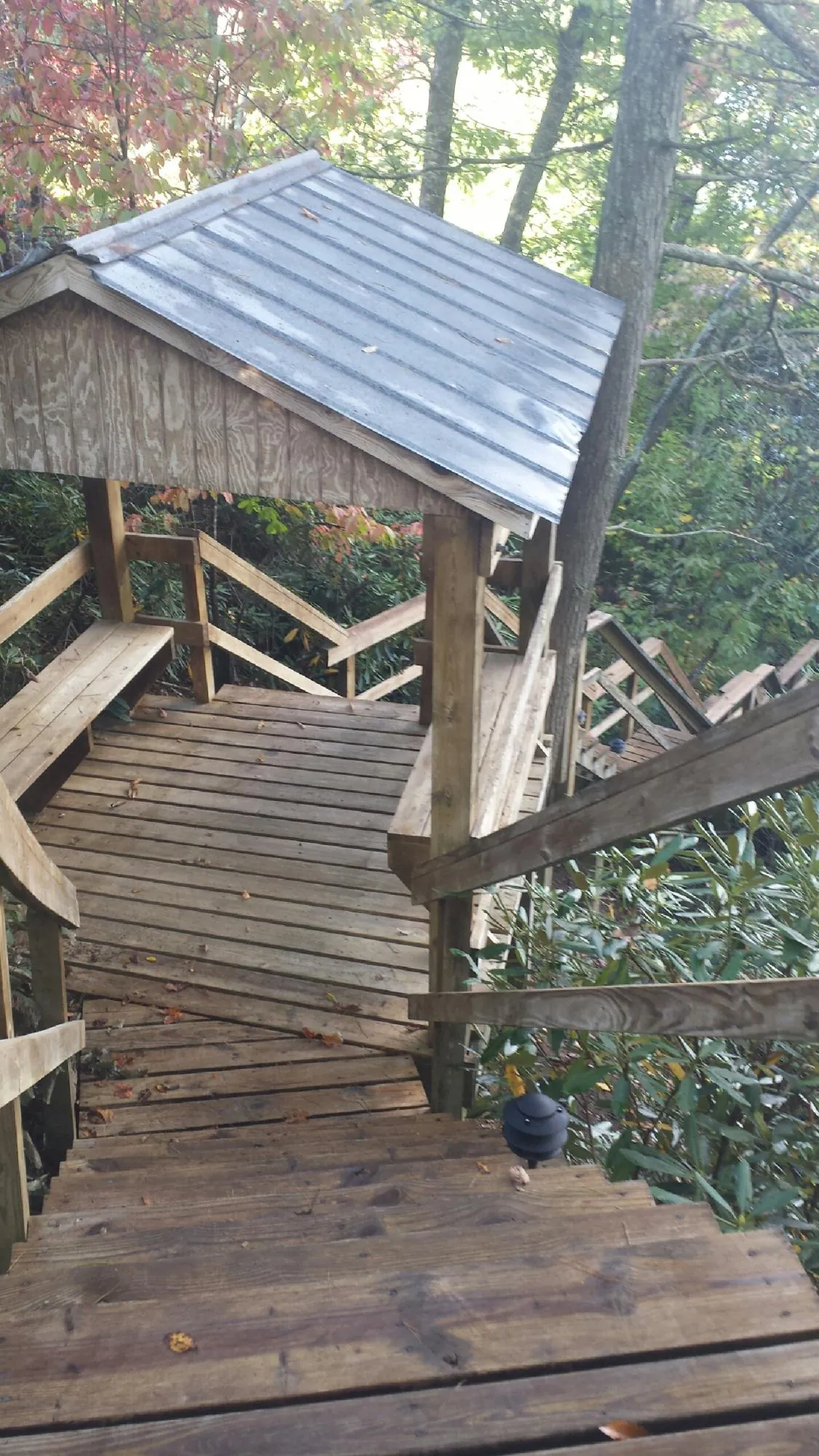 Metal roofed shelter over wooden steps on a wooded walkway — Skylight Repair & Installation work by our crew in Hull